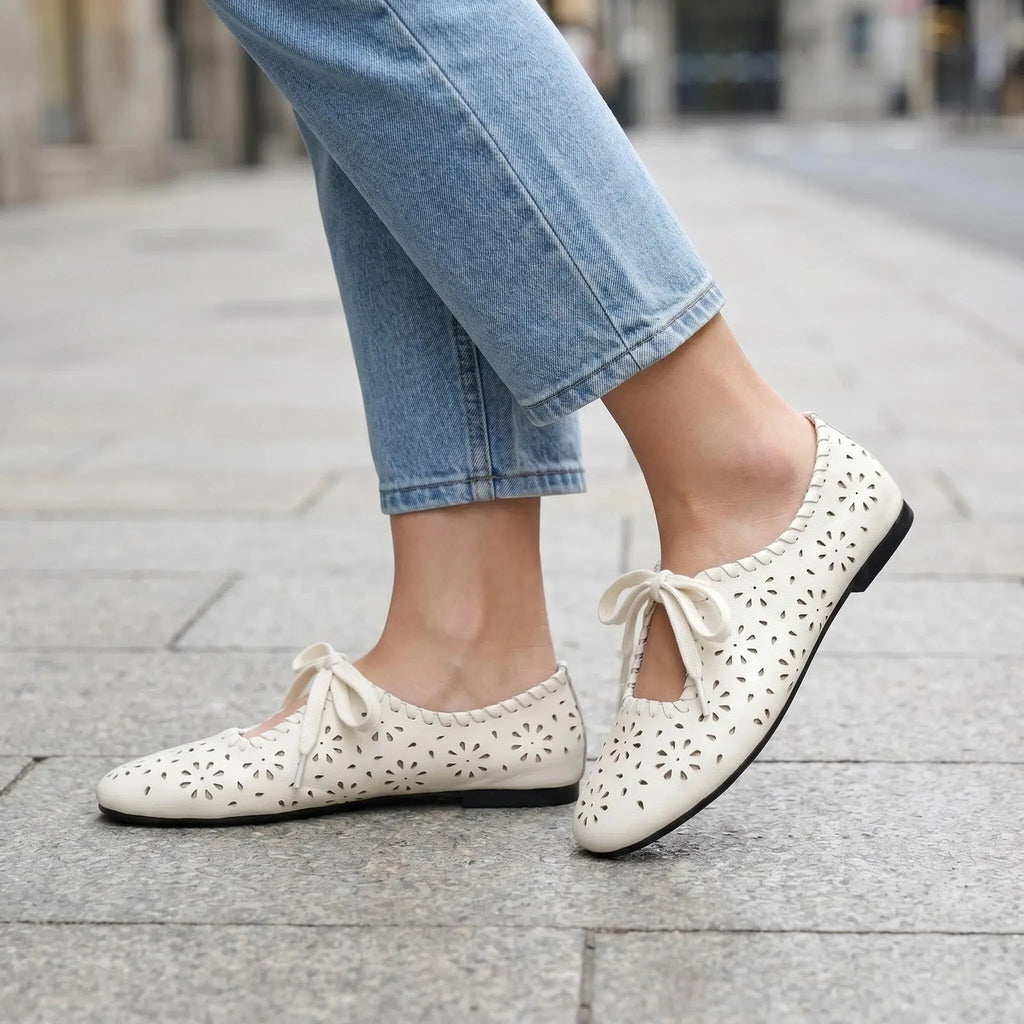 ZQW Lace-Up Cutout Floral Mary Janes in white, worn on feet close-up – floral cutout pattern allows breathability, lace-up front for adjustable fit, cushioned insole for all-day comfort